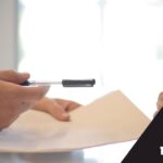יד, מחברת ועט. כיתוב: שמאות רכוש ועולם הביטוח
