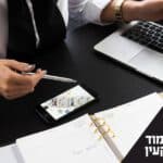 שמאי מקרקעין מול מסמכים ומחשב. כיתוב: האם כדאי ללמוד שמאות מקרקעין
